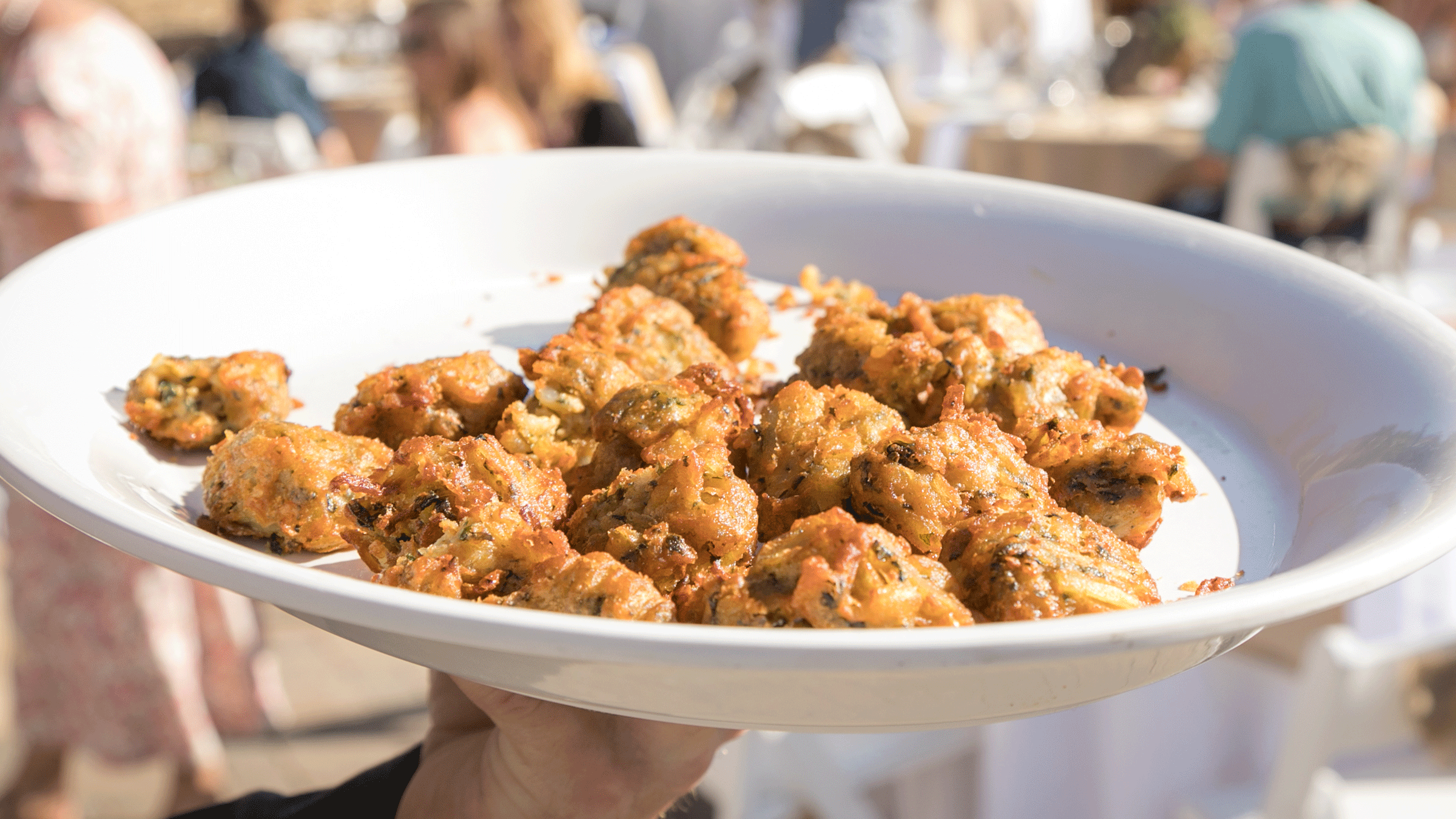 Server holding up a plate of hors d'oeuvres